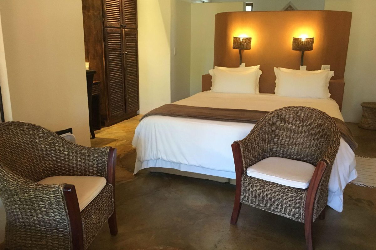 Guest bedroom with wicker chairs at Afrikhaya
